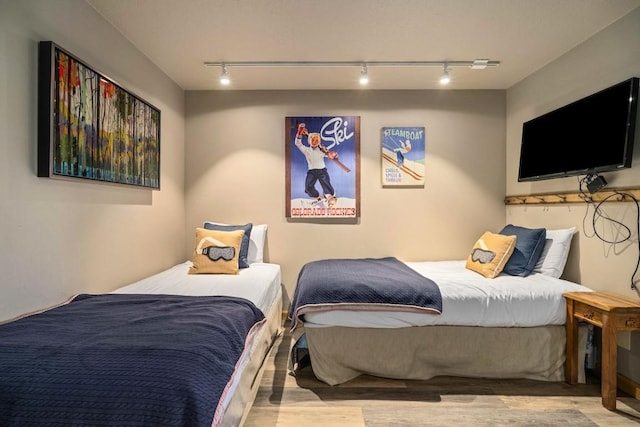 bedroom featuring light hardwood / wood-style floors and track lighting