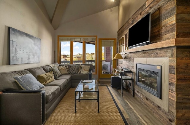 living room featuring hardwood / wood-style floors, high vaulted ceiling, and a tile fireplace