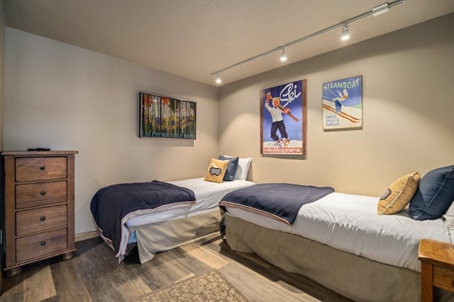 bedroom featuring wood-type flooring and track lighting