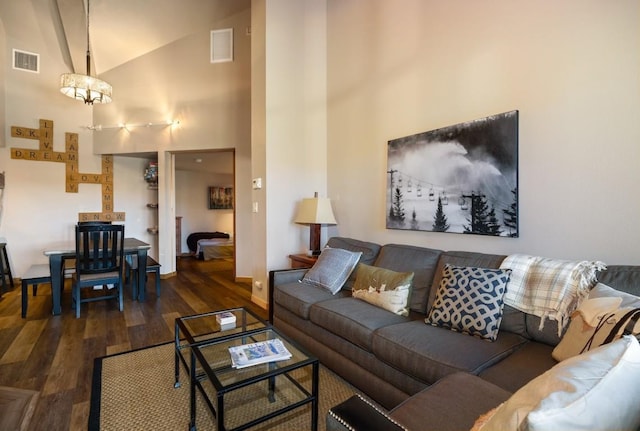 living room featuring high vaulted ceiling, dark hardwood / wood-style floors, and an inviting chandelier