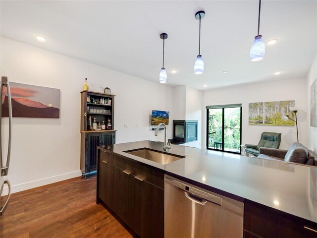 kitchen featuring pendant lighting, dark brown cabinetry, dishwasher, and sink