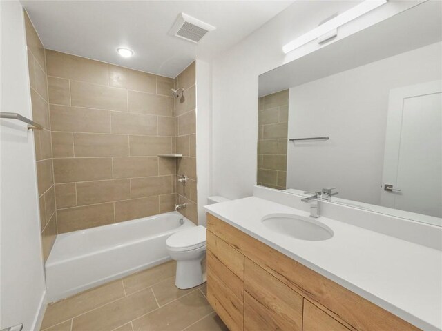 full bathroom featuring vanity, tiled shower / bath combo, tile patterned floors, and toilet