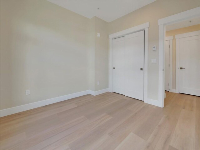 unfurnished bedroom with light hardwood / wood-style floors and a closet