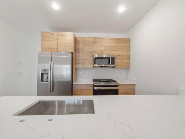 kitchen with appliances with stainless steel finishes and light brown cabinetry