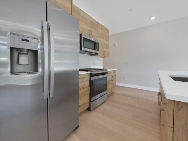 kitchen featuring stainless steel appliances and light hardwood / wood-style floors