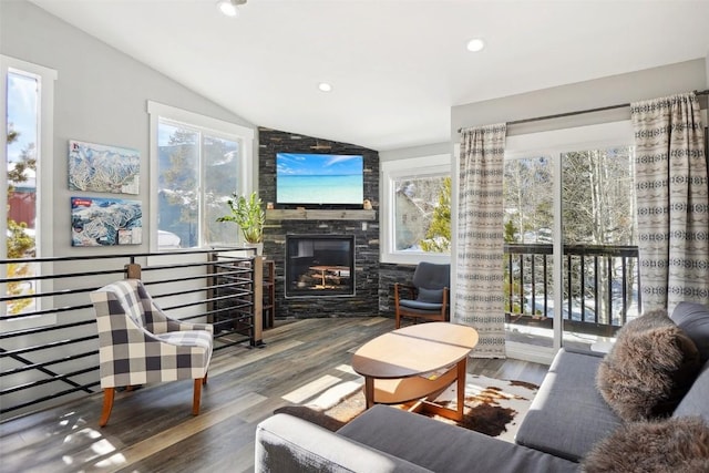 living room featuring lofted ceiling, a large fireplace, recessed lighting, and wood finished floors