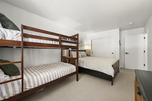 bedroom featuring a textured ceiling and light colored carpet