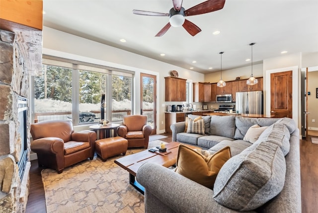 living room featuring light wood-style floors, ceiling fan, baseboards, and recessed lighting