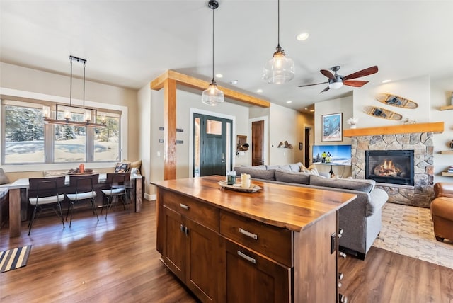 kitchen with recessed lighting, dark wood-type flooring, wood counters, open floor plan, and hanging light fixtures