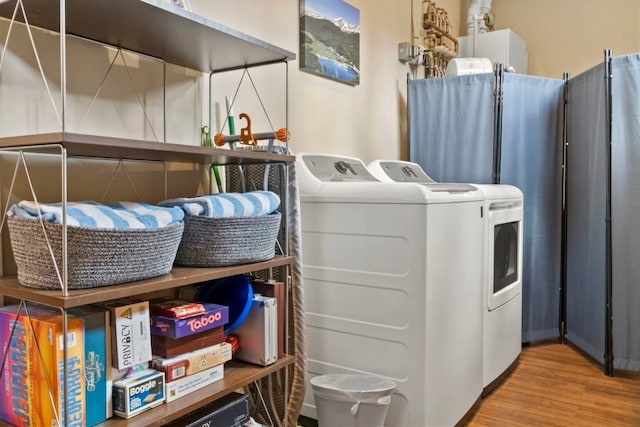 laundry room featuring laundry area, separate washer and dryer, and wood finished floors