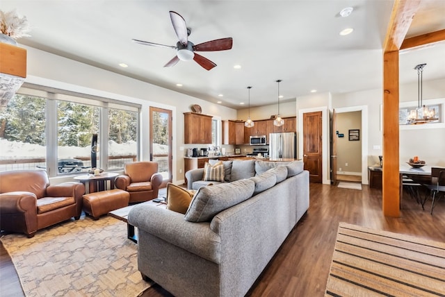 living area with ceiling fan with notable chandelier, baseboards, wood finished floors, and recessed lighting