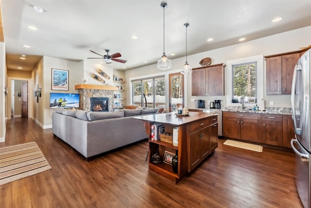 kitchen with dark wood-style floors, recessed lighting, a kitchen island, and freestanding refrigerator