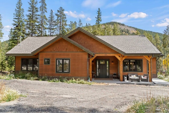 chalet / cabin with an outdoor hangout area, a shingled roof, and a mountain view