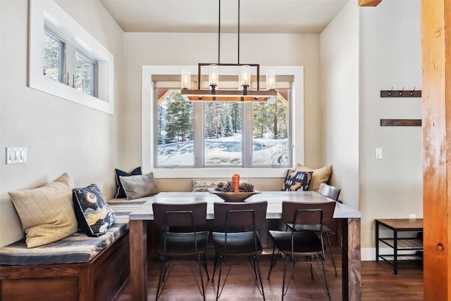 dining area featuring dark wood-style flooring, breakfast area, a wealth of natural light, and baseboards