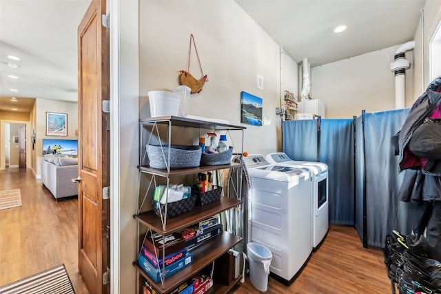 laundry room featuring recessed lighting, laundry area, separate washer and dryer, and wood finished floors