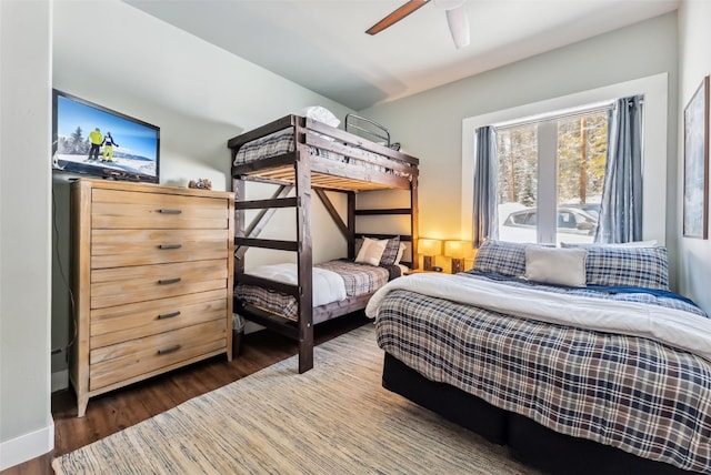 bedroom with ceiling fan, baseboards, and wood finished floors