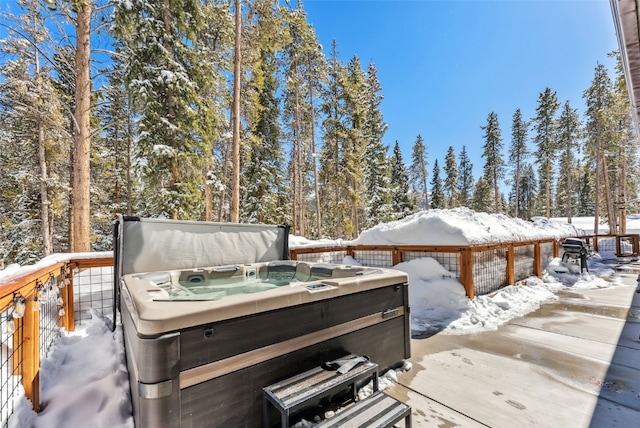 snow covered deck with a hot tub