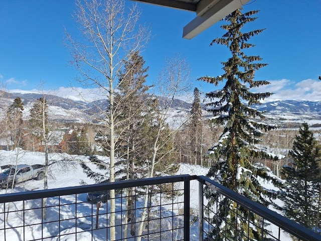 snow covered back of property with a mountain view