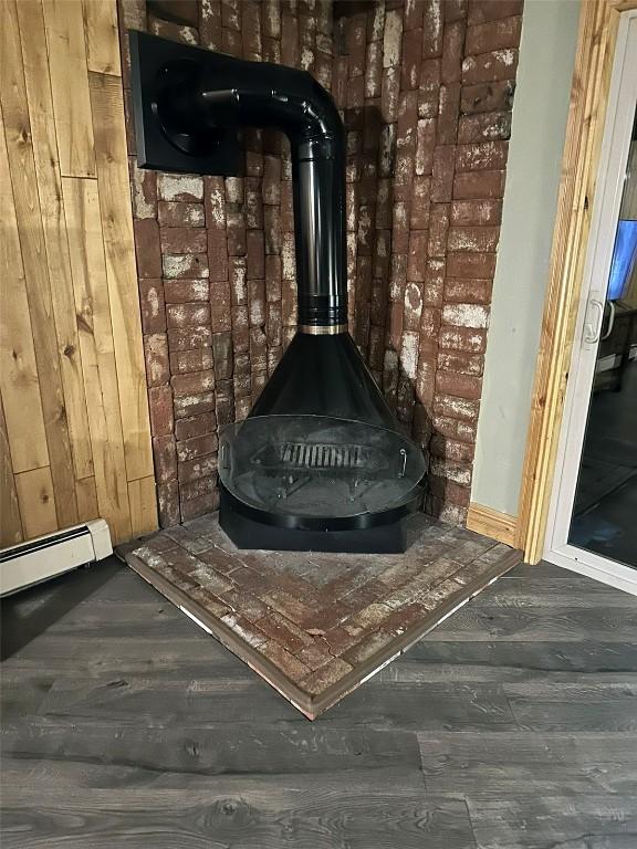 interior details featuring a baseboard radiator, hardwood / wood-style floors, and a wood stove