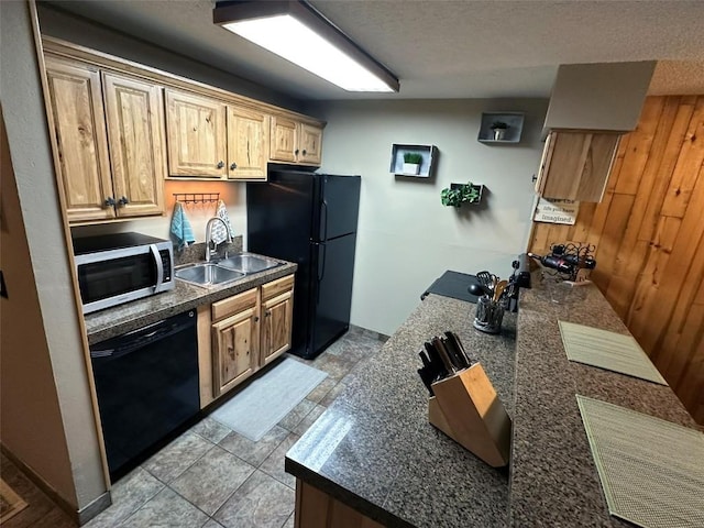 kitchen featuring wood walls, sink, light tile patterned floors, black appliances, and a textured ceiling