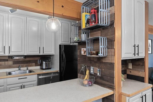 kitchen with black fridge, stainless steel dishwasher, sink, decorative light fixtures, and white cabinets