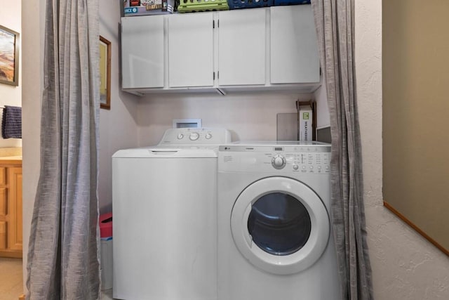 laundry room featuring cabinets and washing machine and clothes dryer