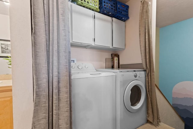 laundry room featuring cabinets and washer and clothes dryer