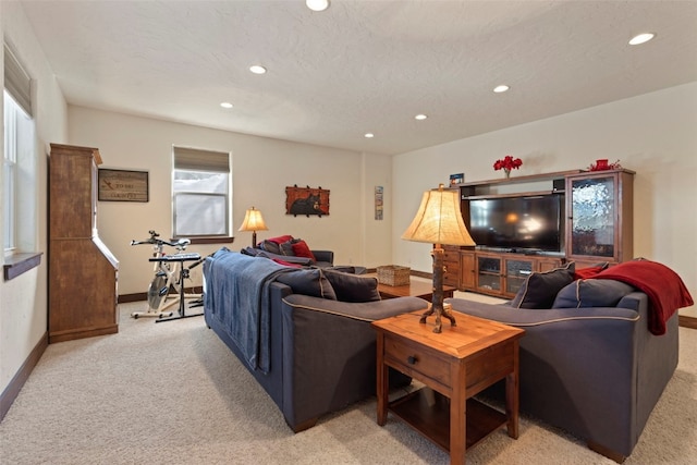 living room with recessed lighting, light carpet, a textured ceiling, and baseboards