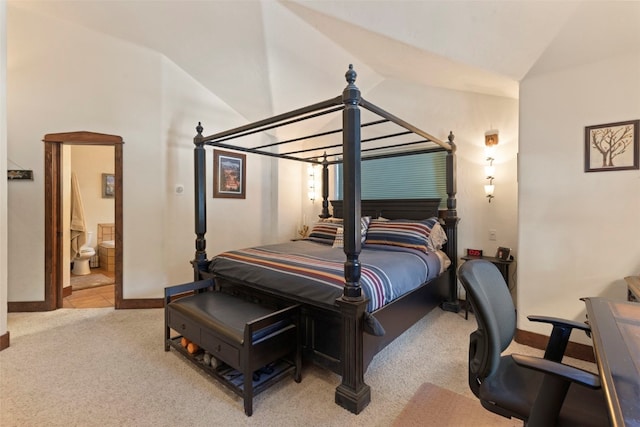 bedroom featuring lofted ceiling, light carpet, connected bathroom, and baseboards