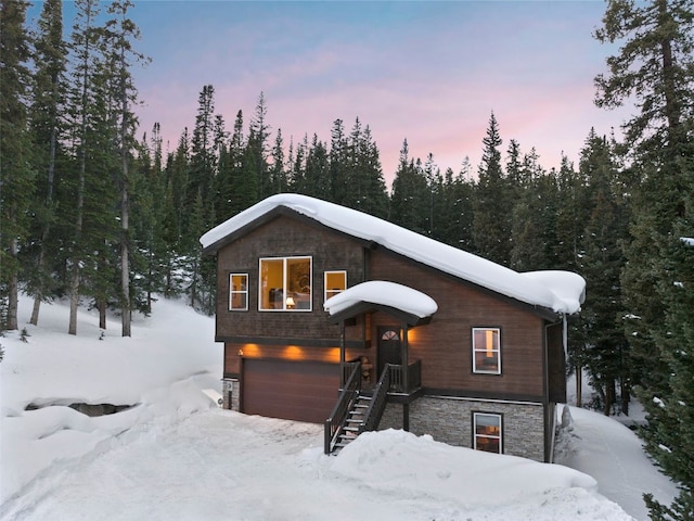 rustic home featuring stone siding and an attached garage