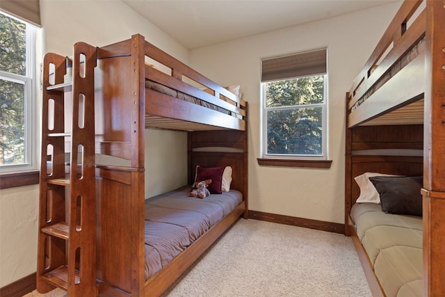 bedroom with carpet, multiple windows, and baseboards