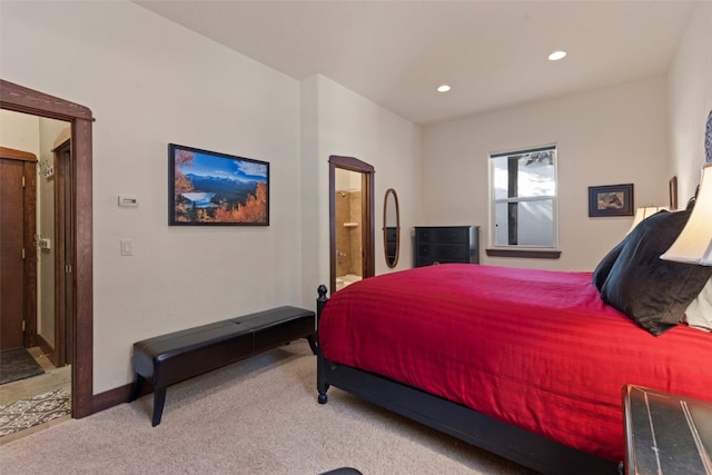 carpeted bedroom with connected bathroom and recessed lighting