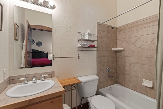 ensuite bathroom featuring a textured wall, connected bathroom, toilet, shower / bath combination, and vanity