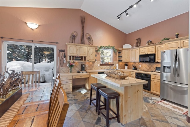 kitchen featuring tile countertops, a kitchen island, light brown cabinetry, black appliances, and open shelves