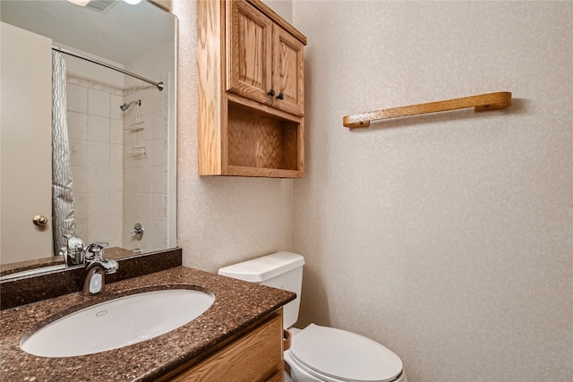 bathroom featuring vanity, toilet, and walk in shower