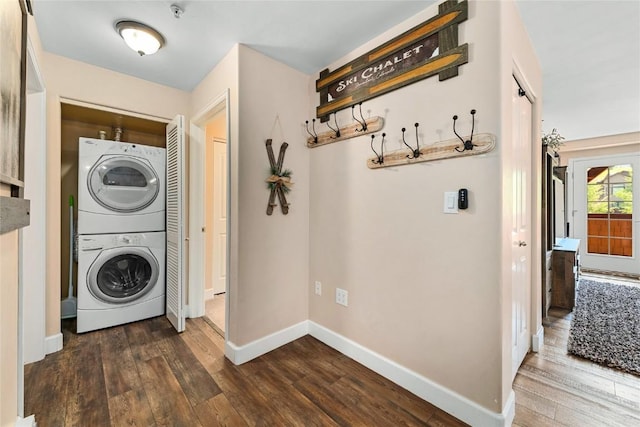 clothes washing area featuring stacked washer and dryer and dark hardwood / wood-style floors