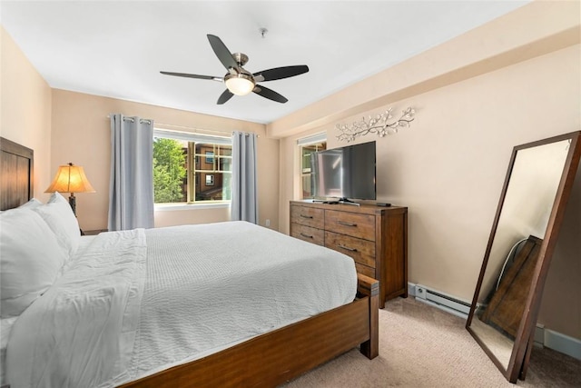 bedroom featuring light carpet, ceiling fan, and a baseboard heating unit