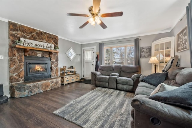 living area with ornamental molding, a fireplace, ceiling fan, and wood finished floors