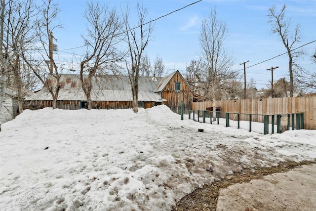 snowy yard featuring fence