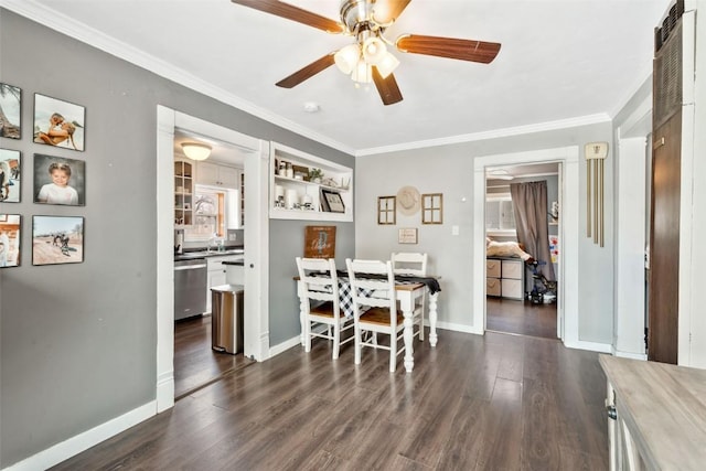 dining area featuring dark wood-style floors, ornamental molding, baseboards, and a ceiling fan