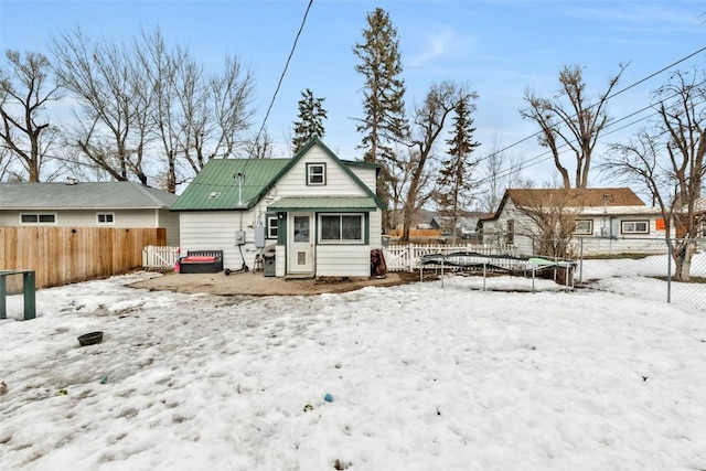 view of front of home with a trampoline and a fenced backyard