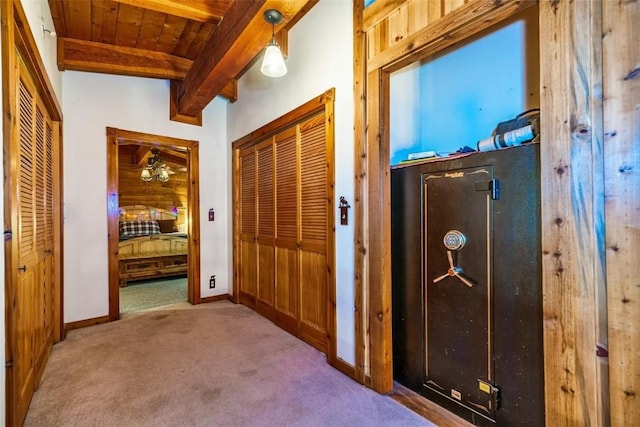 hallway with lofted ceiling with beams, light colored carpet, and wood ceiling