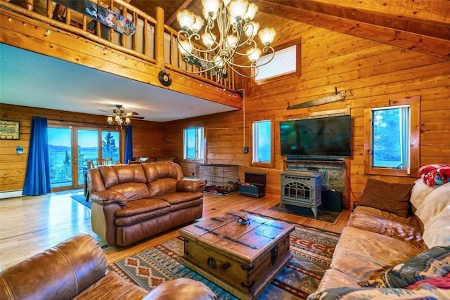 living room with hardwood / wood-style flooring, a wood stove, and wood walls