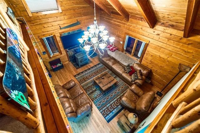 unfurnished living room with hardwood / wood-style floors, lofted ceiling with beams, an inviting chandelier, and wooden ceiling