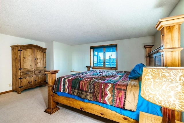 bedroom with light colored carpet and a textured ceiling