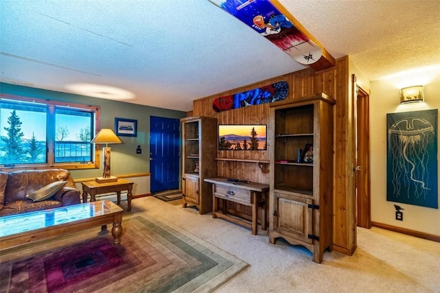 living room featuring carpet, a textured ceiling, and wooden walls