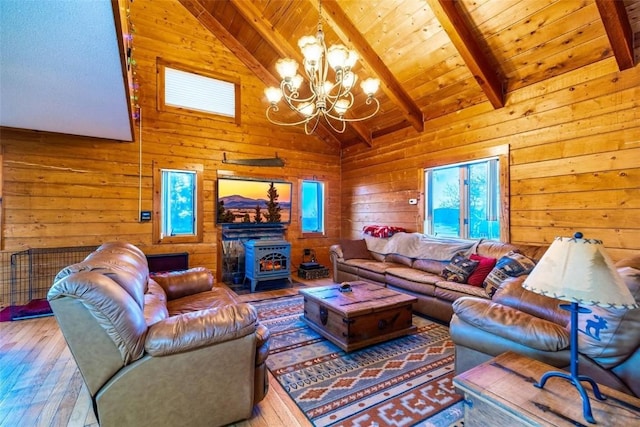 living room featuring a wood stove, beamed ceiling, a notable chandelier, hardwood / wood-style floors, and wood ceiling