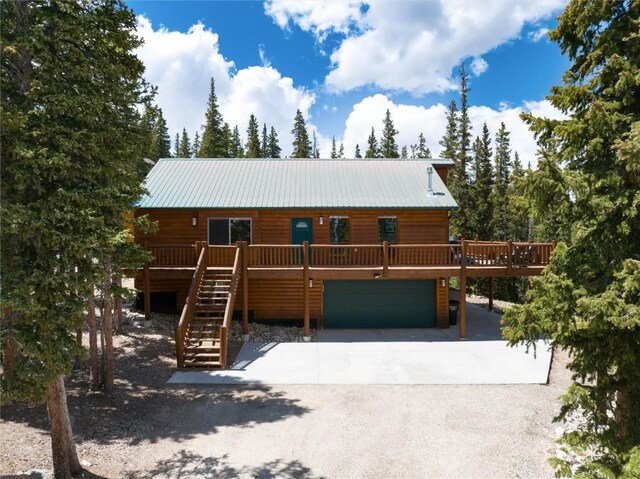 log-style house featuring a wooden deck and a garage