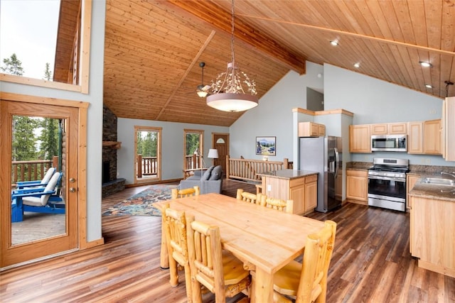 dining area featuring a stone fireplace, dark hardwood / wood-style flooring, high vaulted ceiling, and plenty of natural light