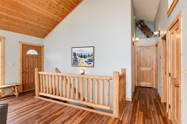 foyer entrance featuring wood ceiling, dark wood-type flooring, and high vaulted ceiling